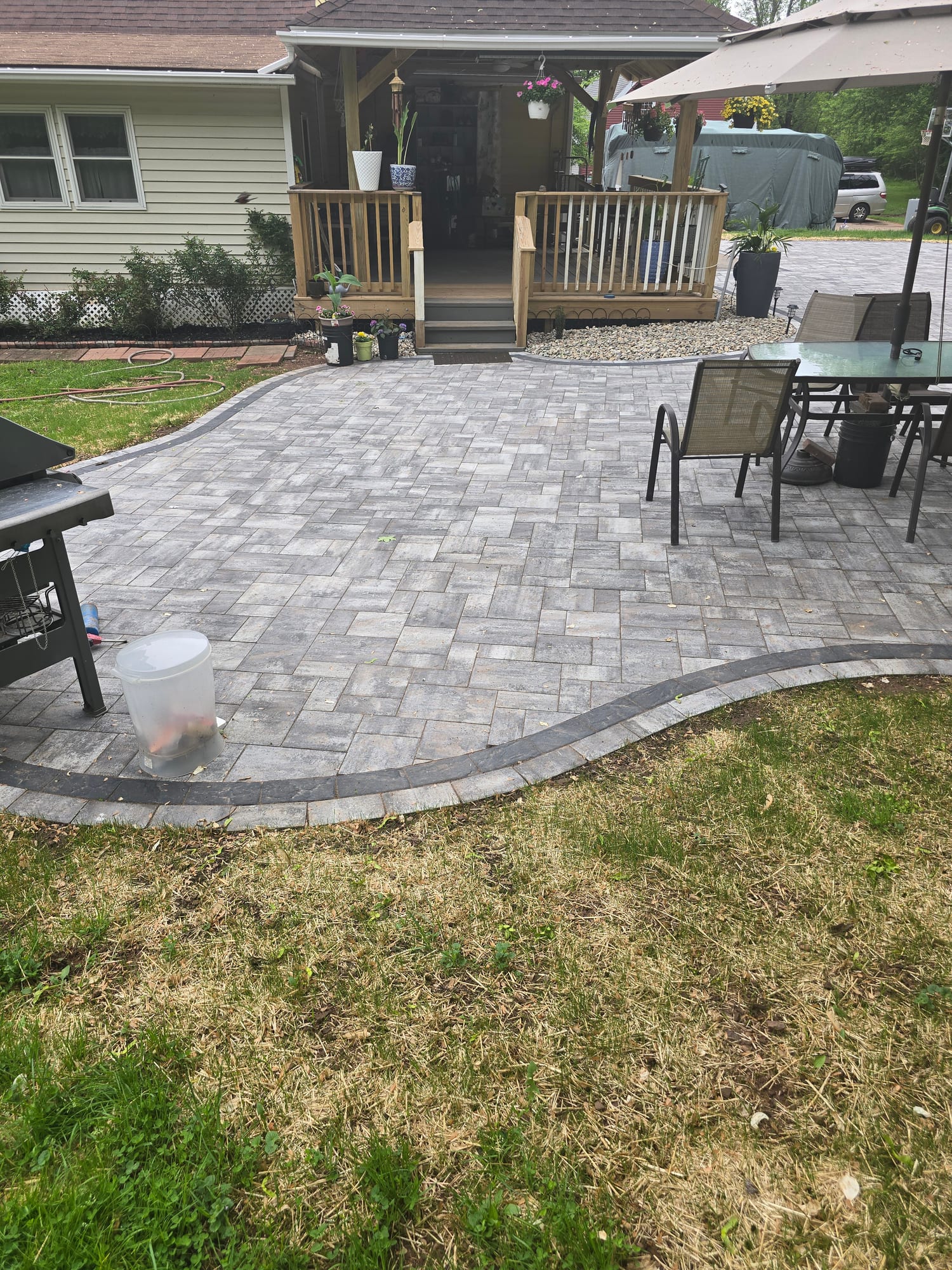 Backyard patio connecting to a deck staircase