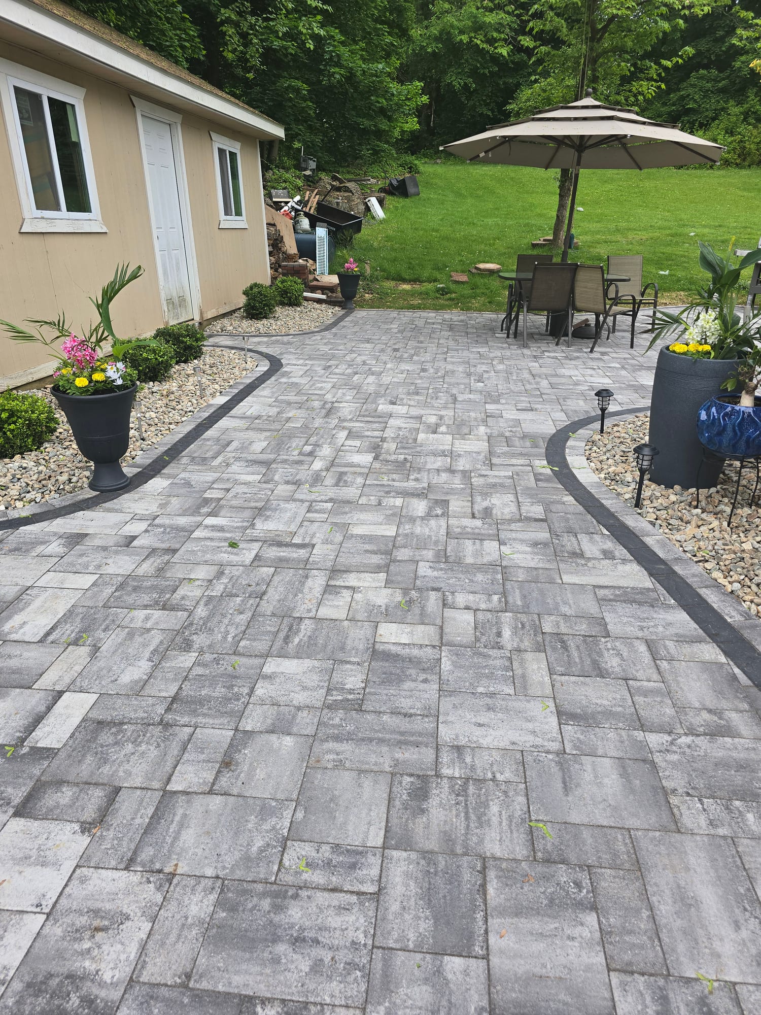 Backyard patio with a curved paver border