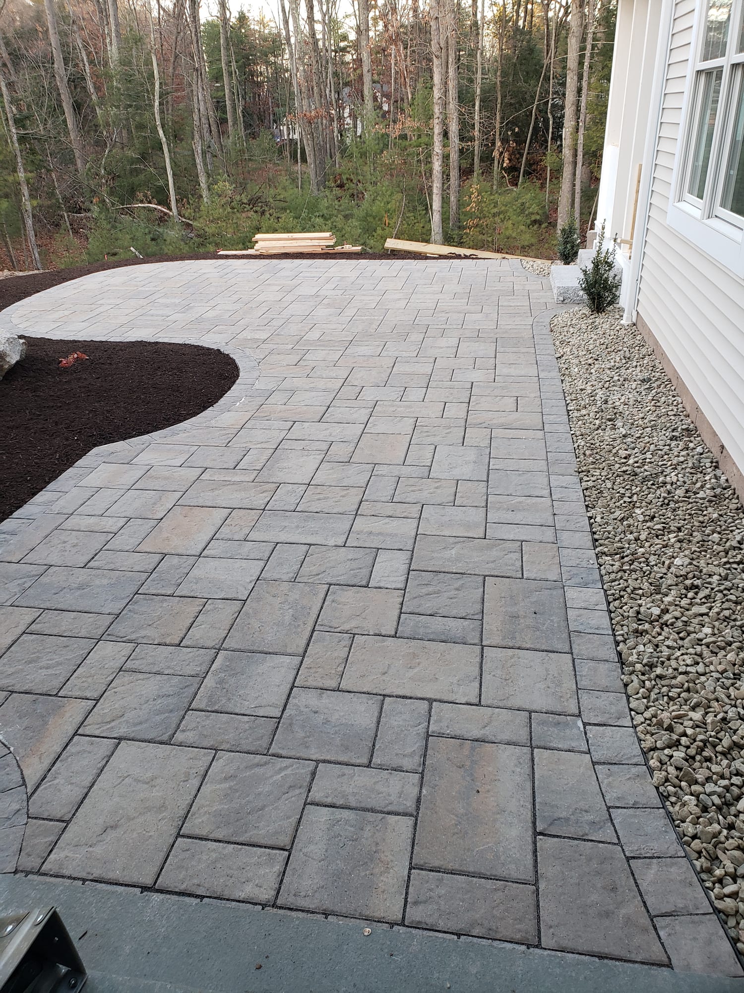 Backyard patio with a curved mulch-bed border