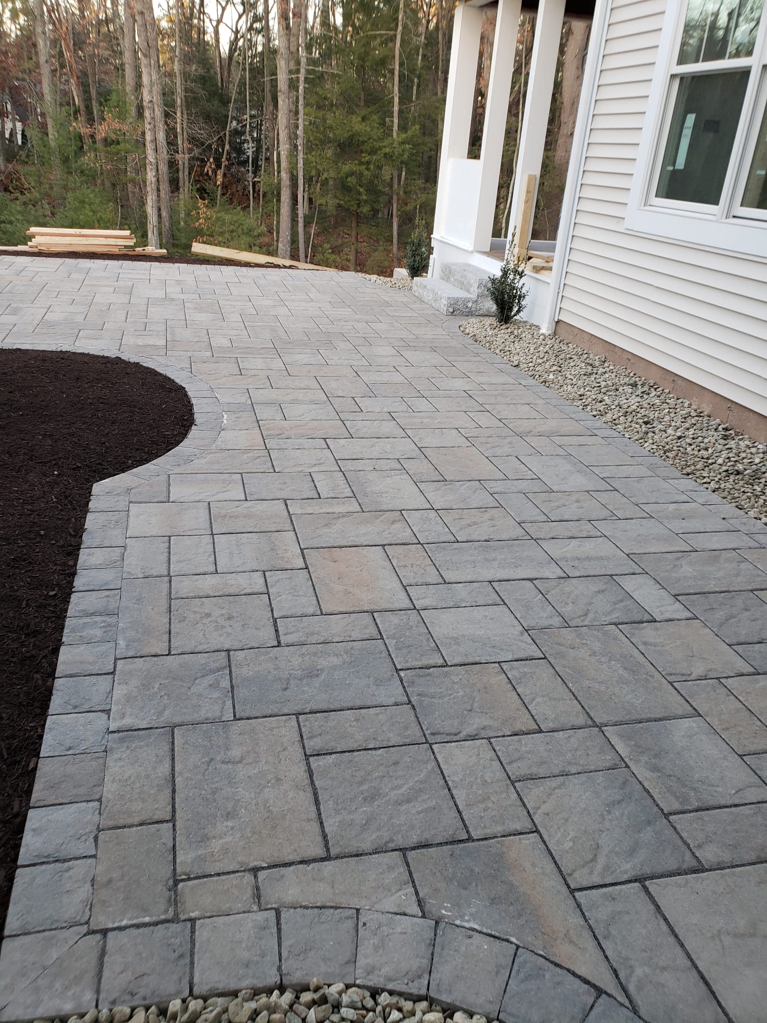 Backyard patio beside a covered porch