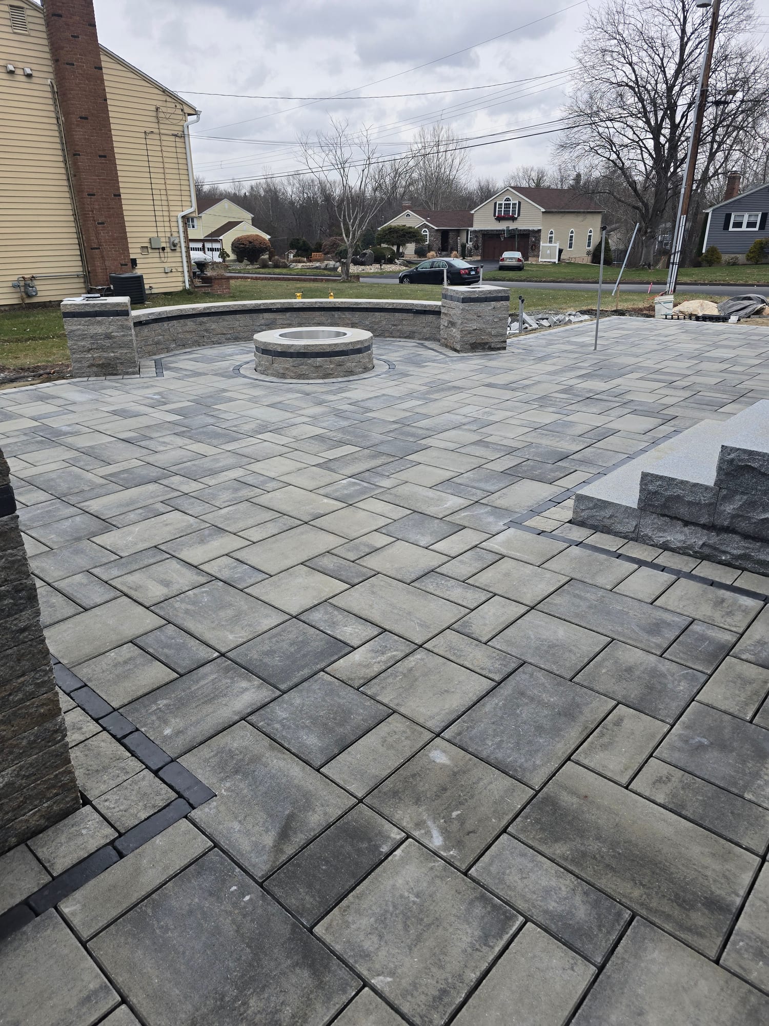 Front yard patio with a fire pit and stone columns